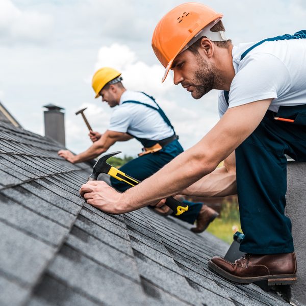 selective focus of handsome handyman repairing roof with coworke Experience the Orlando Roof Tech Difference