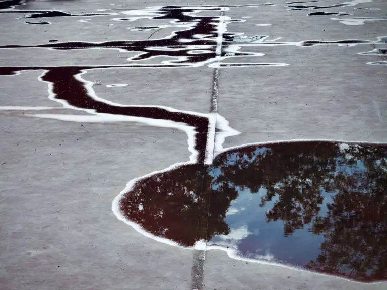 Standing water pooled along a seam on a gray flat roof membrane